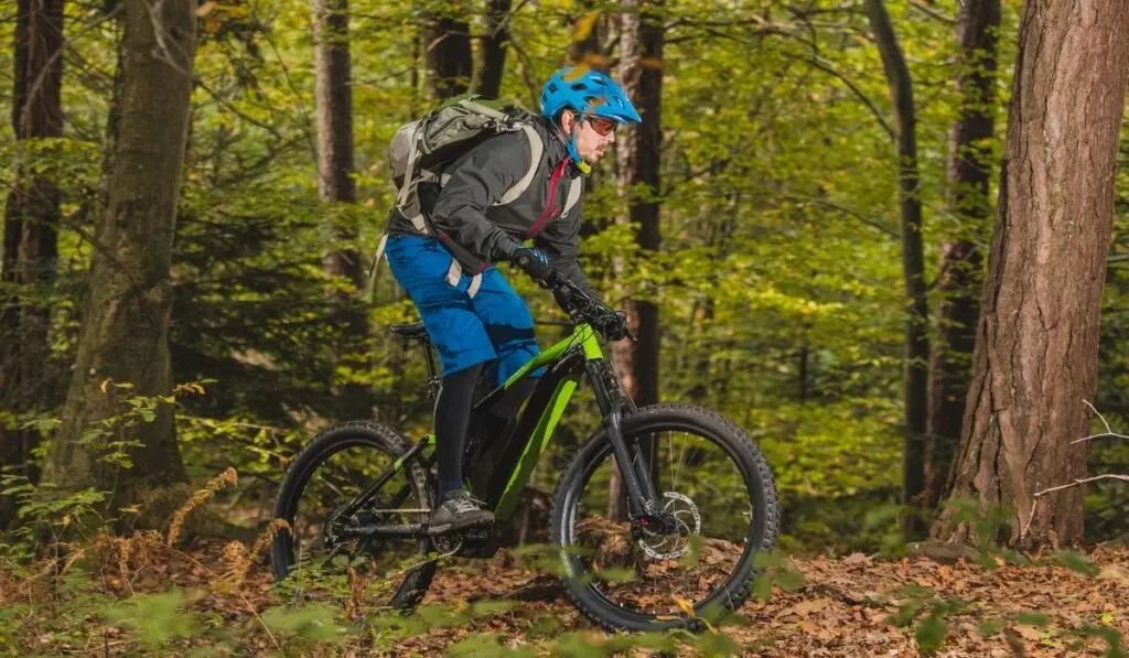 Biker riding uphill with a modern electric bicycle Smaller